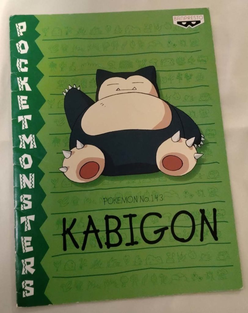 バンプレストよりカビゴンが左手を上げている緑色のノートのデザイン